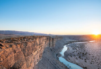 People standing at the Fish River Canyon during sunset, near the Fish River Lodge.