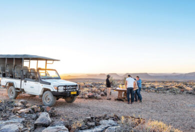 People standing around a bench while on a tour near the Fish River Lodge.