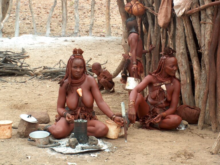 Himba people busy cooking food in their village.