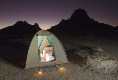 A tent kitted out with luxury bed and bedding